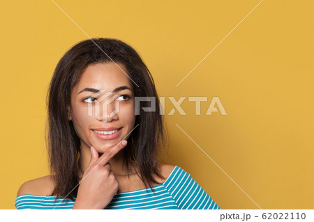 Thinking African American woman on yellow Thinking African American woman on yellow 62022110