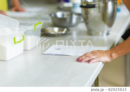 The cook is studying the recipe before cooking 62025015