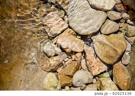 Stones in clear water, sun reflection, summertime. Natural background, top view, close up Stones in clear water, sun reflection, summertime. Natural background, top view, close up 62025136