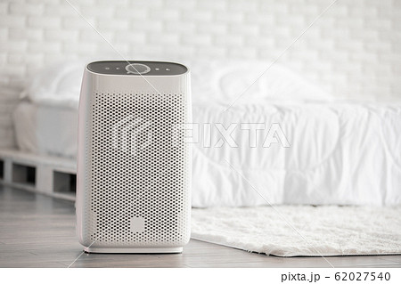 Air purifier in cozy white bed room for filter and cleaning removing dust PM2.5 HEPA in home Air purifier in cozy white bed room for filter and cleaning removing dust PM2.5 HEPA in home 62027540