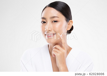 Beautiful Asian young woman touching soft cheek smile with clean and fresh skin Beautiful Asian young woman touching soft cheek smile with clean and fresh skin 62028006