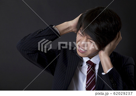 頭をかかえる男性 62029237