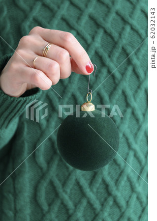 Woman wearing green holding green bauble 62032143