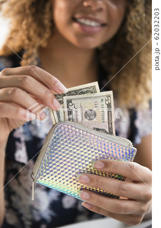 Smiling woman holding wallet with money Smiling woman holding wallet with money 62032203