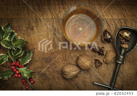 Mistletoe, drink in glass, walnuts and nut cracker 62032455