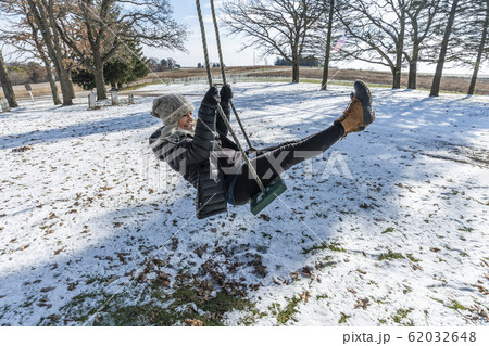 Woman on swing in snow 62032648
