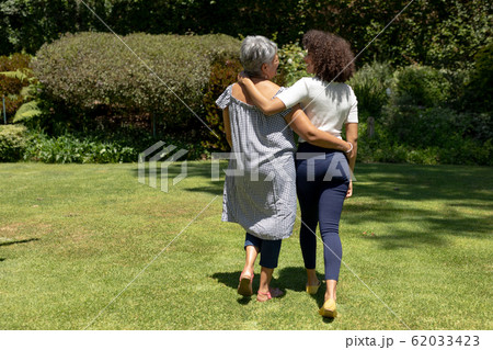 Two women walking in the garden Two women walking in the garden 62033423