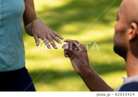 Young man doing marriage proposal in the garden Young man doing marriage proposal in the garden 62033424
