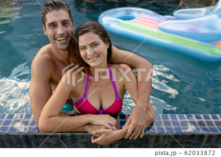 Happy young couple relaxing in the swimming pool Happy young couple relaxing in the swimming pool 62033872