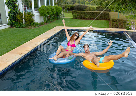 Happy young couple relaxing in the swimming pool Happy young couple relaxing in the swimming pool 62033915