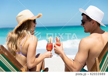 Young couple drinking at the beach 62033989