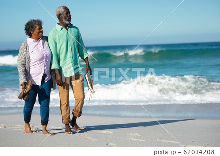 Old couple walking at the beach 62034208