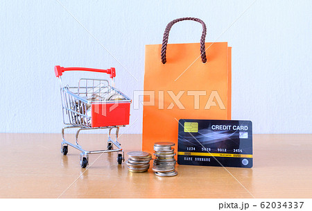 Cart supermarket and orange paper bag on wood Cart supermarket and orange paper bag on wood 62034337