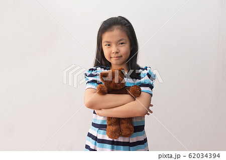 asia girl hugging a teddy bear 62034394