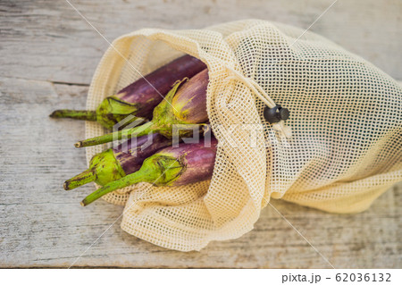 Eggplant in a reusable bag on a stylish wooden kitchen surface. Zero waste concept Eggplant in a reusable bag on a stylish wooden kitchen surface. Zero waste concept 62036132
