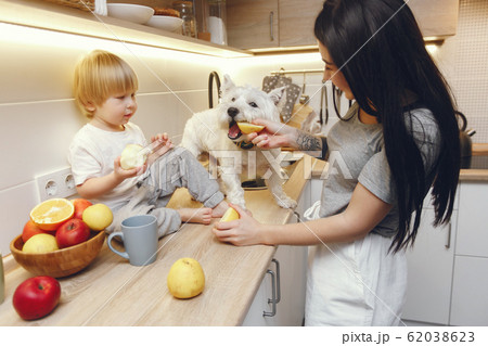 Mother with little son eating fruits in a kitchen 62038623