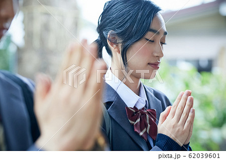 神社でお参りする高校生カップル 62039601
