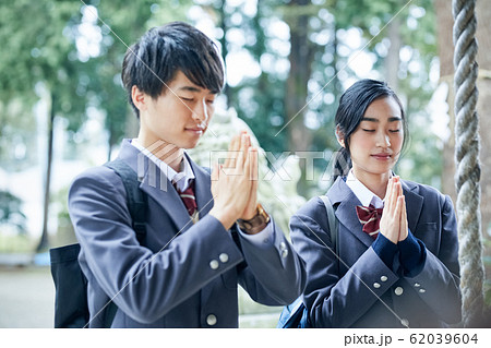 神社でお参りする高校生カップル 62039604