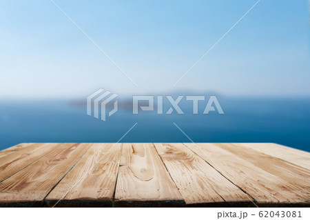 Wooden empty surface on blurry background of coastal sea in afternoon. 62043081