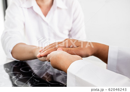 The female doctor uses a friendly hand to hold the hand of the patient to give confidence after the x-ray and advise on health care. Medical concepts and good health The female doctor uses a friendly hand to hold the hand of the patient to give confidence after the x-ray and advise on health care. Medical concepts and good health 62046243