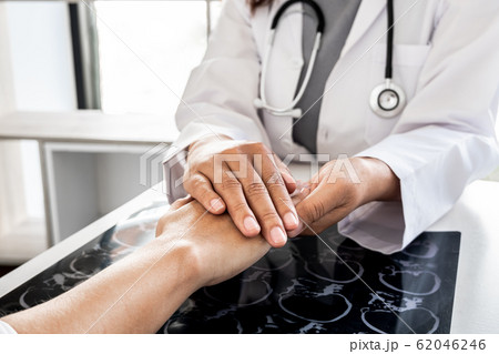 The female doctor uses a friendly hand to hold the hand of the patient to give confidence after the x-ray and advise on health care. Medical concepts and good health The female doctor uses a friendly hand to hold the hand of the patient to give confidence after the x-ray and advise on health care. Medical concepts and good health 62046246