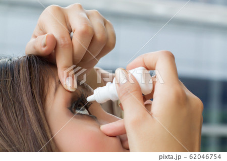 woman using eye drop, eye lubricant to treat dry woman using eye drop, eye lubricant to treat dry 62046754