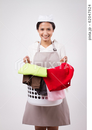 happy smiling asian woman carrying laundry basket; happy smiling asian woman carrying laundry basket; 62047624