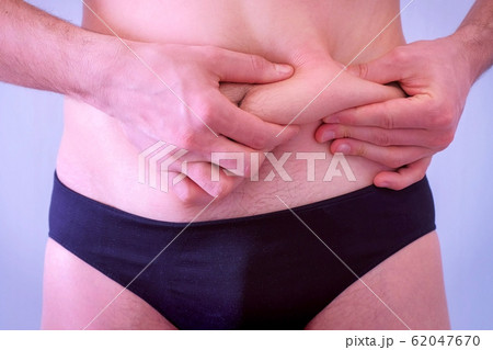 Slim man in underpants touches his flabby fat naked stomach, closeup view. Slim man in underpants touches his flabby fat naked stomach, closeup view. 62047670