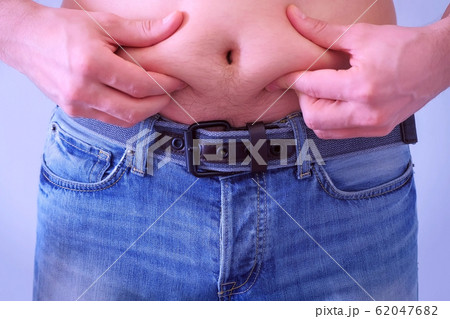 Man touches his flabby fat naked stomach, closeup view. 62047682