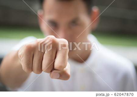 man punching; strong man clenching his fist man punching; strong man clenching his fist 62047870