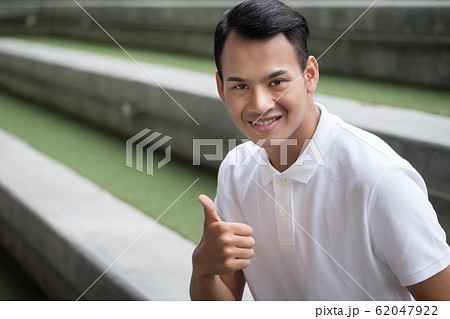happy man giving thumb up gesture; smiling 62047922