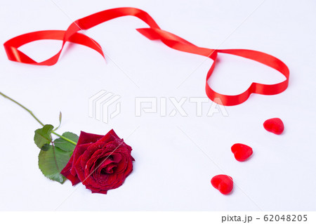 Red rose, ribbon and hearts on a white background. Valentine's Day, Birthday, Mother's Day, International Women's Day. Close-up, selective focus. 62048205