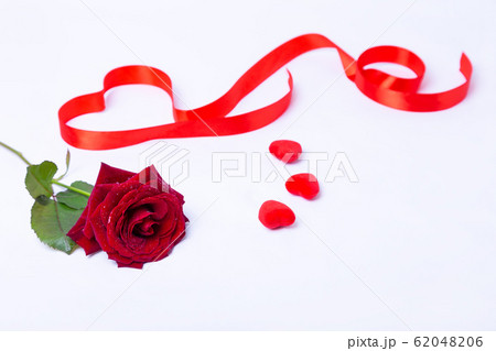 Red rose, ribbon and hearts on a white background. Valentine's Day, Birthday, Mother's Day, International Women's Day. Close-up, selective focus. 62048206