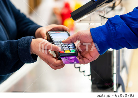 Close up of using credit card pos terminal to pay. Hands entering the password of creditcard for payment. Close up of using credit card pos terminal to pay. Hands entering the password of creditcard for payment. 62050792