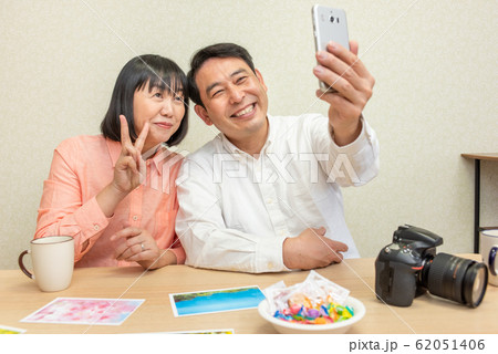 スマホで自撮りをする中高年の夫婦 62051406