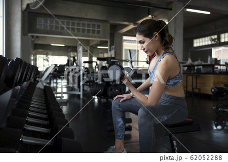 Young asian woman lifting dumbbells in gym 62052288