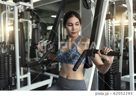 Young asian woman lifting barbell in gym. Young asian woman lifting barbell in gym. 62052293
