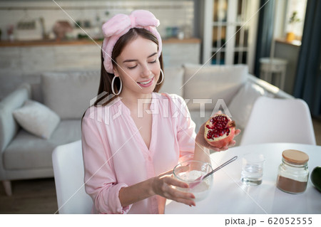 Young pretty girl in a pink headband holding a pomegranate 62052555