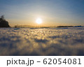 Winter frosty day. The time of sunset. Bokeh snowflakes sparkle in the sun 62054081