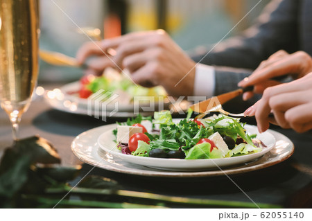 Closeup Of Unrecognizable Couple Eating Greek Salad At Dinner In Restaurant 62055140