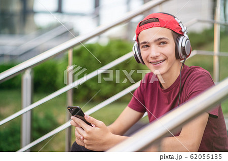 Young man listen to the music in a big earphones, 62056135