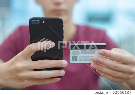 Close-up human hands with mobile phone and credit Close-up human hands with mobile phone and credit 62056137