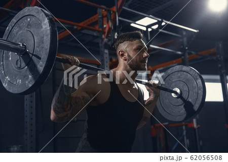 The male athlete training hard in the gym. Fitness and healthy life concept. 62056508