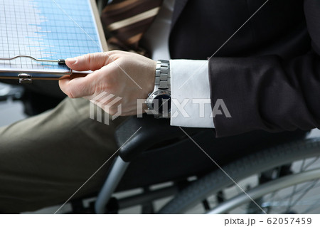 Disabled man holds business chart in hand while sitting 62057459