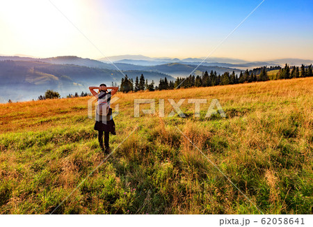 Young woman inhales the aroma of wild herbs Young woman inhales the aroma of wild herbs 62058641