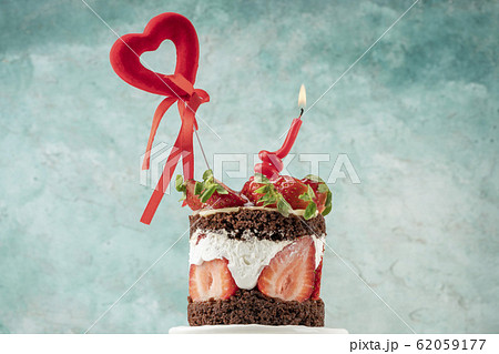 birthday cake with strawberry has one candle 62059177