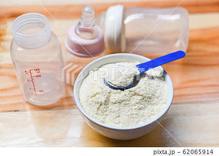 Milk powder in spoon from can and baby bottle milk Milk powder in spoon from can and baby bottle milk 62065914
