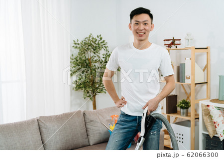 guy face camera smiling holding vacuum cleaner guy face camera smiling holding vacuum cleaner 62066300