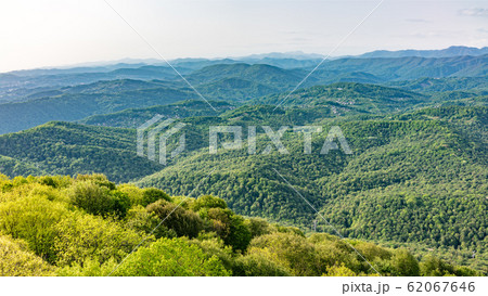 Layers of mountains in the haze during sunset. 62067646