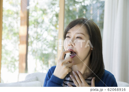 喉スプレーをする若い女性 62068916